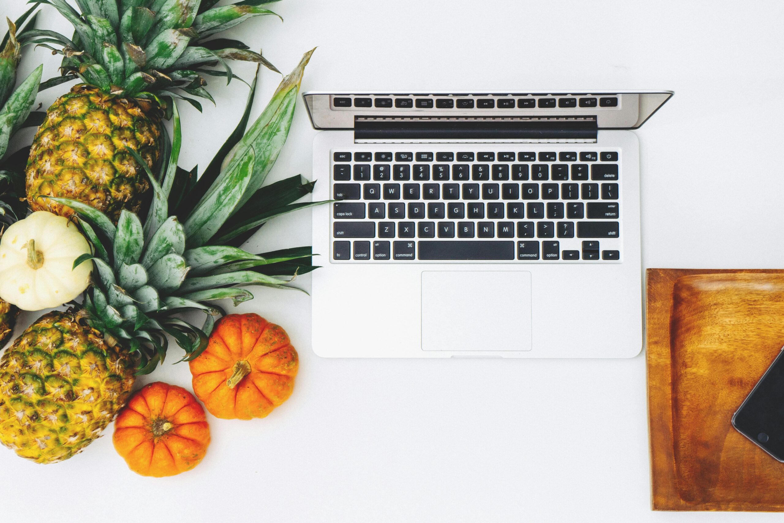 Weißes Macbook In Der Nähe Von Ananas Und Kürbis